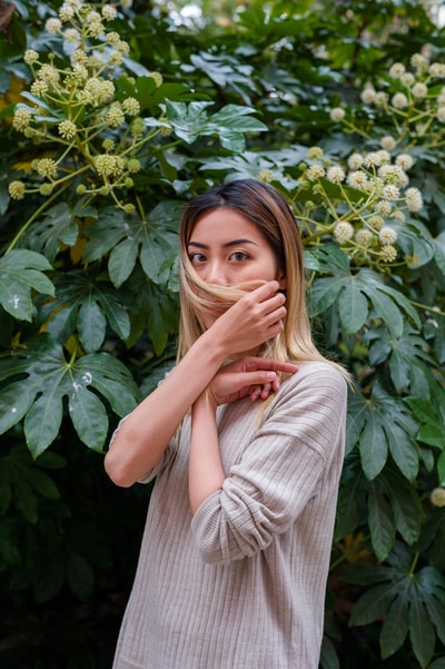 The woman standing in front of the green plants
